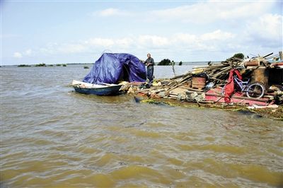 15日，因黑龍江水位上漲，一位轉移家中物資被困屋頂?shù)睦先讼蛎窬笾Ｐ氯A社發(fā)