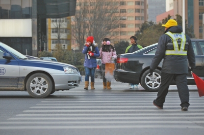 過(guò)斑馬線，行人左顧右盼，汽車寸土必爭(zhēng)。