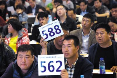 昨日，拍賣現(xiàn)場競拍者舉牌競拍。新京報(bào)記者