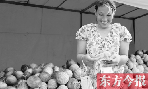 昨日，開封瓜農(nóng)史瑩瑩幸福地?cái)?shù)著賣瓜錢