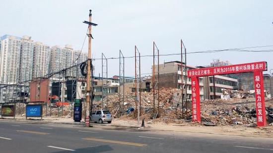015年5月31日，在社區(qū)干部的帶頭拆遷下，親賢社區(qū)的“城中村改造”拉開帷幕。由于前期“清產(chǎn)核資”及補(bǔ)償標(biāo)準(zhǔn)等因素，拆遷改造工作推進(jìn)并不順利。圖為位于體育西路東側(cè)集體所有的商鋪率先被拆遷完畢，用于遮擋的圍擋正在施工中。（拍攝：2015年9月16日）