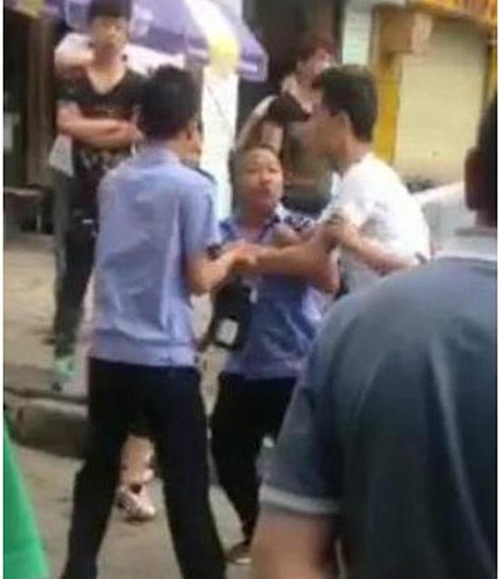 付某（右）與城管執(zhí)法人員廝打在一起。
