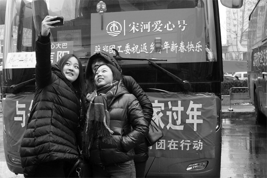 昨天上午8時(shí)，鄭州正道中環(huán)百貨廣場(chǎng)，準(zhǔn)備回家的老鄉(xiāng)在愛(ài)心大巴車(chē)前合影留念