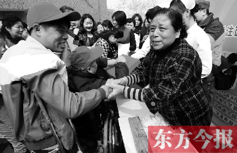昨日，鄭大四附院的大樓前，“面人鄭”鄭玉芬（右）向前來(lái)捐款的殘疾人表示感謝