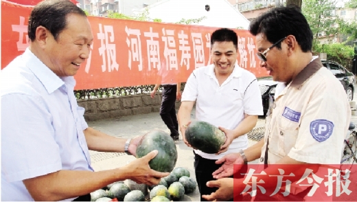 河南福壽園區(qū)域總經(jīng)理吳正宗（左一）、東方今報(bào)發(fā)行中心副總監(jiān)王路喜（中）在街頭給市民送瓜
