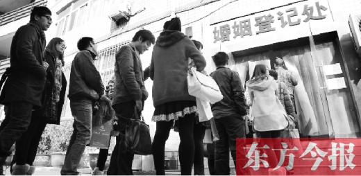 昨日，鄭州市中原區(qū)婚姻登記處等待“領證”的情侶們將隊伍延伸至辦事大廳大門外