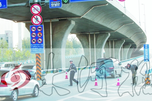 交警在東風(fēng)路從北向南上橋口處擺上反光錐，間歇放行