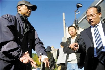 常林鋒在法院外展示雙手，他稱被燙傷的手因刑訊逼供且未得到及時(shí)救治