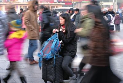 春運(yùn)首日，北京站客流量明顯增多，一名女孩在人流中等待進(jìn)站。