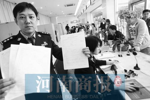 　民警左手拿的是新申請表，右手拿的是三份老申請表 王春勝/攝
