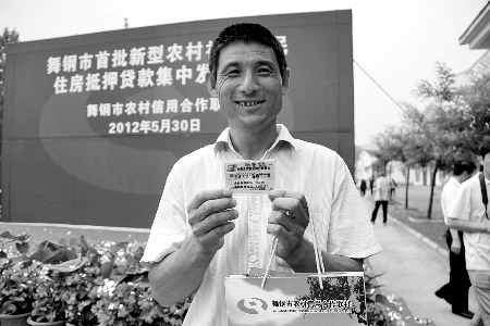 領(lǐng)到貸款，農(nóng)民開(kāi)心地笑了。