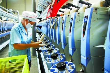 7月3日，在鄧州市永泰棉紡有限公司電腦控制全自動紡紗車間，紡織工人正在生產(chǎn)棉紗。