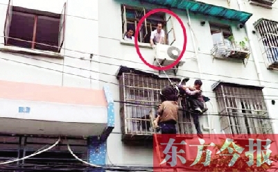 施救現(xiàn)場(chǎng)，劉鵬（圈內(nèi)）先用繩子捆住老太確保安全 勞動(dòng)報(bào)記者 郭娜 供圖
