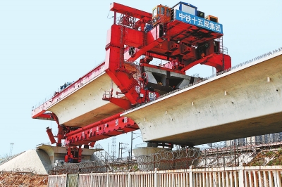 建設(shè)者們操縱巨型起重機(jī)在吊放橋墩。記者鄧放攝