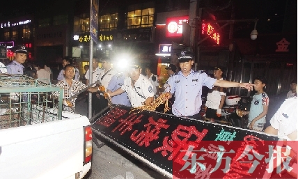 7月8日晚，鄭州市商城路一家占道經(jīng)營的攤販招牌被執(zhí)法隊員“登記保存”