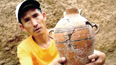 　　考古工作人員展示出土的仰韶文化時期代表性彩陶。