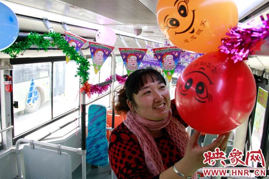 鄭州快速公交B3區(qū)間線車長李鵬云在車廂里懸掛氣球，布置圣誕車廂，營造歡樂圣誕氛圍