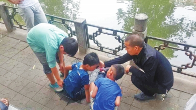 男孩被救出后，圍觀群眾幫他控水換衣服。