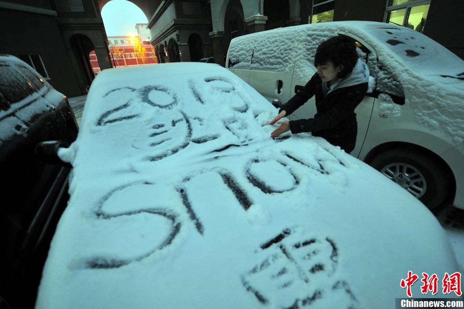 11月18日，行人在車輛的積雪上涂鴉。