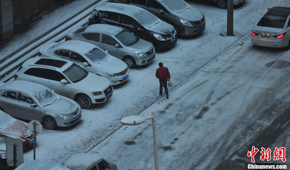 11月18日，行人在沈陽街頭的積雪中穿行。
