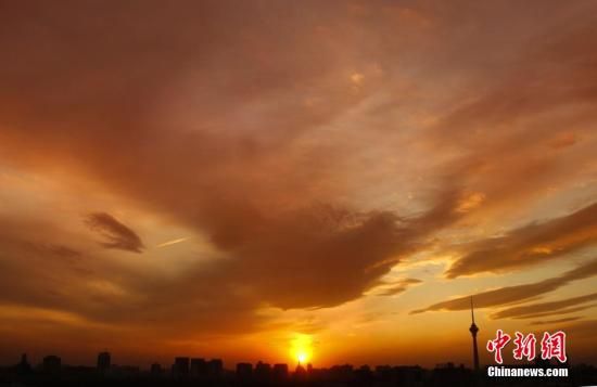 12月8日下午，強(qiáng)烈的西北風(fēng)光臨北京，吹散了籠罩全城上空的霧霾，冬日罕見(jiàn)的艷麗晚霞映紅了半邊天。