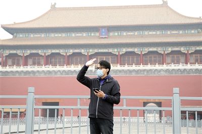 11月1日，北京大部分地區(qū)重度污染，一名游客戴著口罩在午門前揮手跟朋友打招呼。 實(shí)習(xí)生 王飛 攝