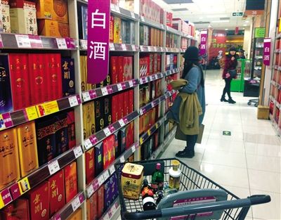 顧客在商場(chǎng)的高檔白酒貨架前駐足挑選。春節(jié)臨近，受“禁令”影響，以高檔白酒為代表的節(jié)日禮品市場(chǎng)面臨考驗(yàn)。記者 王遠(yuǎn)征 攝