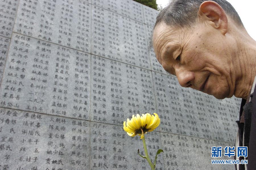 2006年4月5日，74歲的南京大屠殺幸存者佘子清手捧鮮花，祭奠被日軍殺害的母親。