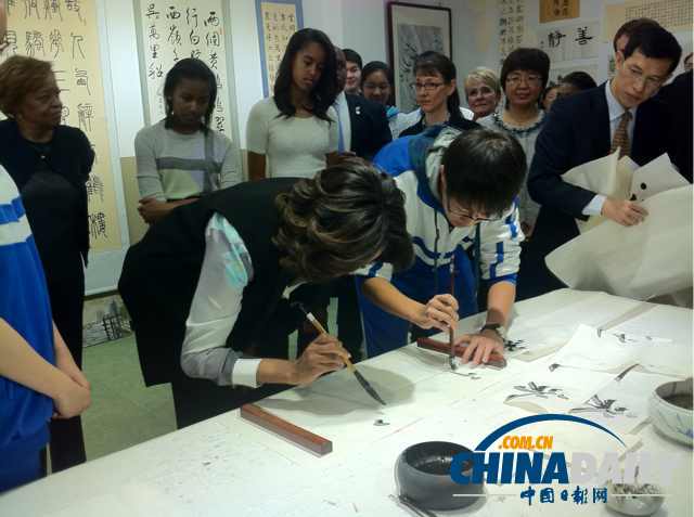 　北京時(shí)間3月21日，美國第一夫人米歇爾參觀北師大二附中時(shí)，與學(xué)生一起練習(xí)書法。