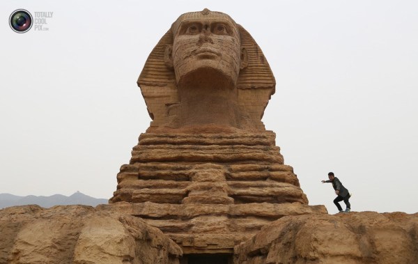 石家莊郊外，一名男子與山寨版獅身人面像合影留念。