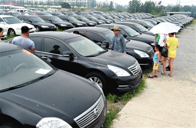 昨日，市民在山東棗莊一家拍賣公司場地上查看待拍賣公車。當日，棗莊市103輛公車公開拍賣。新華社記者