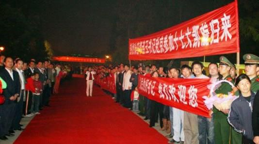 “夾道歡迎”中不少人打出橫幅，路上被鋪上了紅毯。