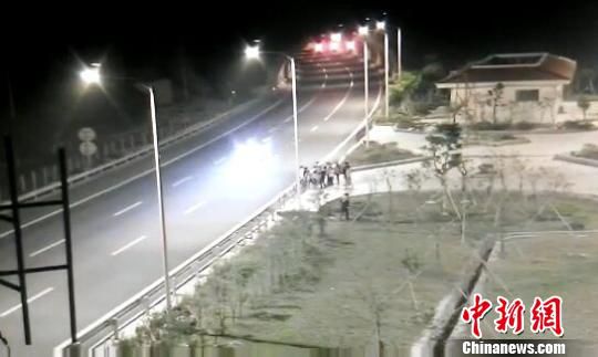 看到車輛經(jīng)過(guò)，孩子們便急忙跑到一旁的花圃上?！【焦﹫D　攝