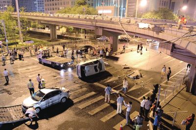 路虎沖下國貿(mào)橋砸中一輛起亞轎車，橋上厚達(dá)幾十厘米的水泥護(hù)欄被撞斷，碎石四處散落，數(shù)十群眾在現(xiàn)場圍觀。