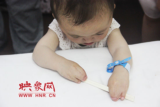 孩子握著筷子發(fā)呆。