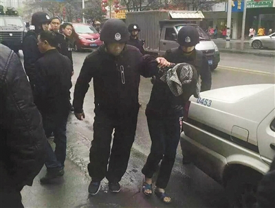 達(dá)州市警方押解剛被抓獲的犯罪嫌疑人褚思練（裹頭巾者）。 本組圖片/新華社