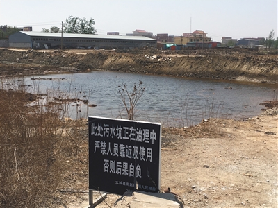 化肥廠滲坑的三分之一經(jīng)過治理，但水質(zhì)仍然呈黃褐色。