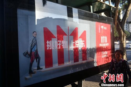 資料圖：11月1日，福州民眾從雙十一廣告牌前經(jīng)過。中新社記者 呂明 攝