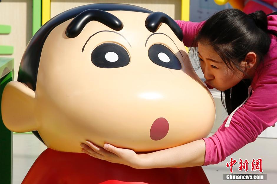 4月22日，游客與蠟筆小新合影?！跋灩P小新25周年紀(jì)念特展”日前在北京開(kāi)展，吸引了不少市民游客。
