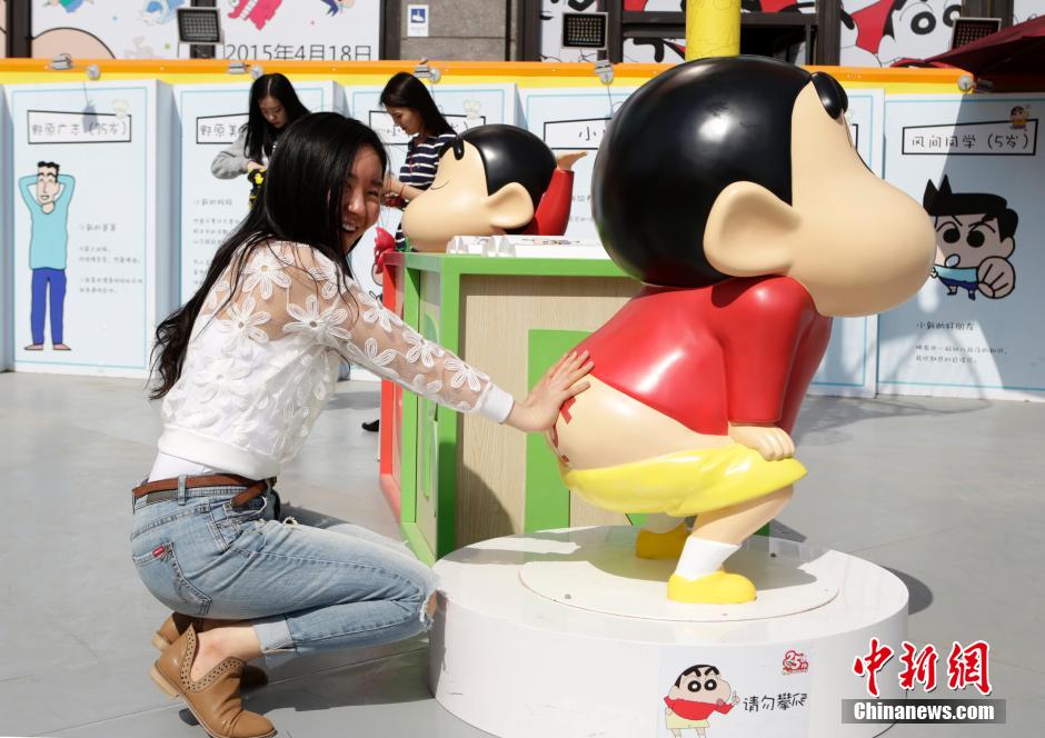 4月22日，游客與蠟筆小新合影?！跋灩P小新25周年紀(jì)念特展”日前在北京開(kāi)展，吸引了不少市民游客。