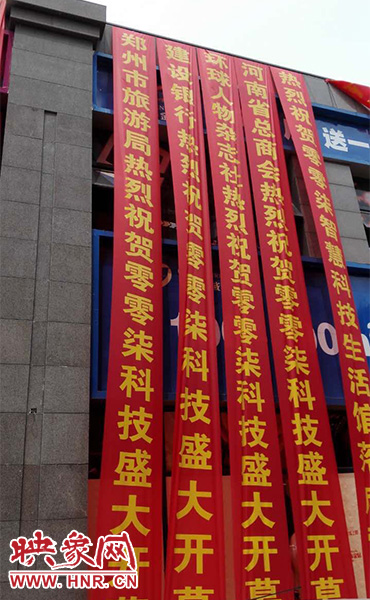 路邊一棟樓上懸掛著二三十條紅色條幅，全部是祝賀一家公司開業(yè)的。