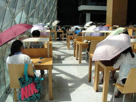 2015年8月2日，深圳圖書館，“太陽曬進(jìn)來很熱的，我們都要撐著傘讀書?！? complete=
