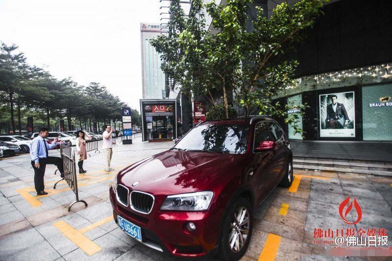 一輛停在停車位上的寶馬轎車，被墜落的樹枝砸中，樹枝徑直插入車內(nèi)，現(xiàn)場引發(fā)不少市民圍觀拍照。