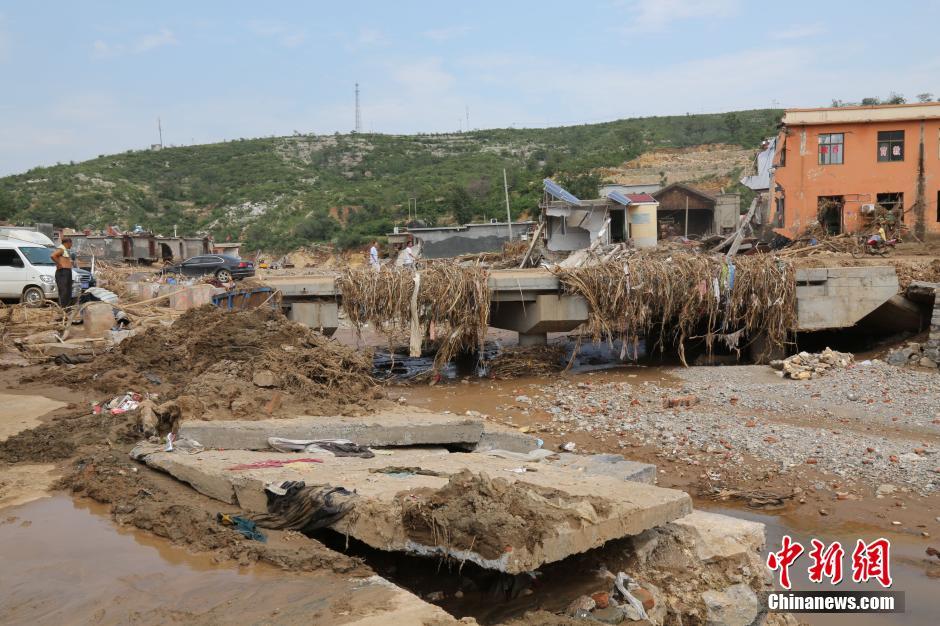 圖為洪水過后，坍塌的橋梁上遺落大量雜草。