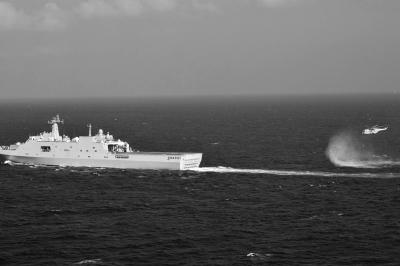 11日，抵達(dá)馬航飛機失聯(lián)海區(qū)的海軍井岡山艦與艦載直升機協(xié)同展開立體搜救行動。新華社發(fā)