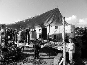 黎巴嫩一敘利亞難民營(yíng)，難民支起攤鋪賣衣服掙錢。