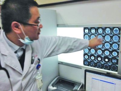 醫(yī)生在查看男孩的腦部CT片。薛馬義 攝