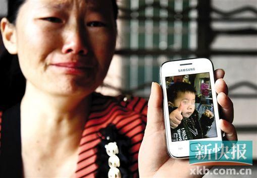 男童的舅媽拿著小益的照片,悲痛欲絕。 新快報記者 畢志毅 攝