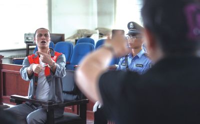 張志國在法庭上用手語回答提問。記者 蒲東峰攝
