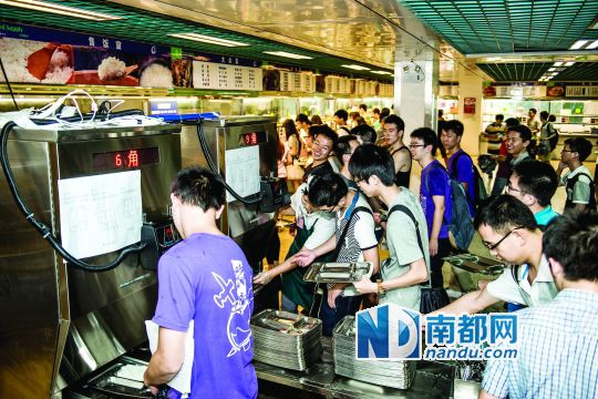 昨日，華南理工大學(xué)一食堂內(nèi)，學(xué)生們正在使用新安裝的自動打飯機打飯。中新社發(fā)